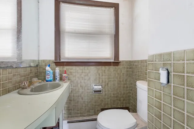 a bathroom with a sink a toilet and mirror