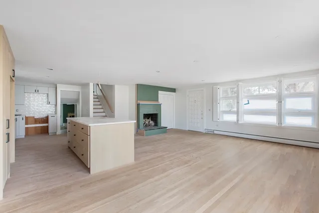 a view of a big room with wooden floor and fireplace