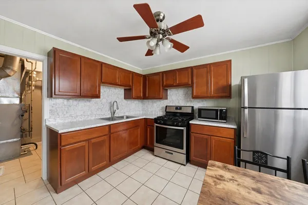 a kitchen with stainless steel appliances granite countertop a refrigerator sink and stove