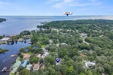 a view of a house with a yard and large trees