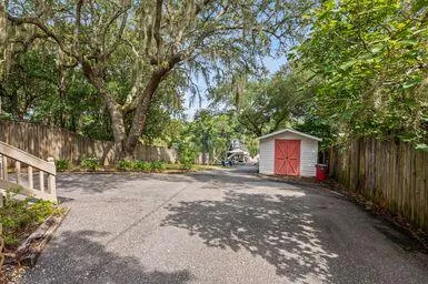 a view of a backyard with small cabin and wooden fence