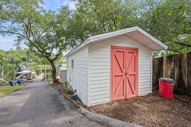a view of backyard with wooden fence and a large tree