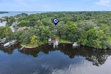 an aerial view of a house with a yard and lake view