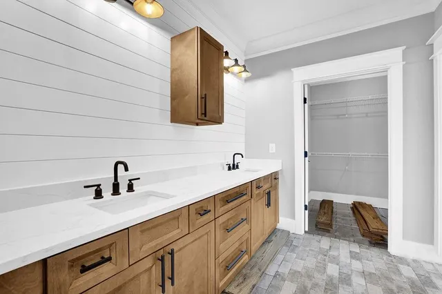 a bathroom with a double vanity sink a mirror and a bathtub