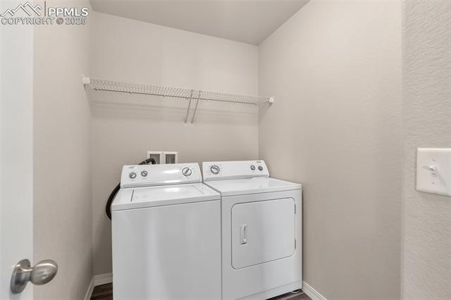 11053 Avena Road Peyton, CO 80831 - Photo 16 of 27 Washroom featuring washing machine and dryer and wood finished floors