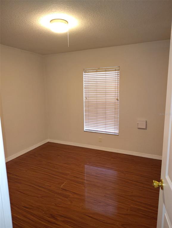 153 Rosedale Avenue Spring Hill, FL 34606 - Photo 12 of 16 an empty room with wooden floor and windows