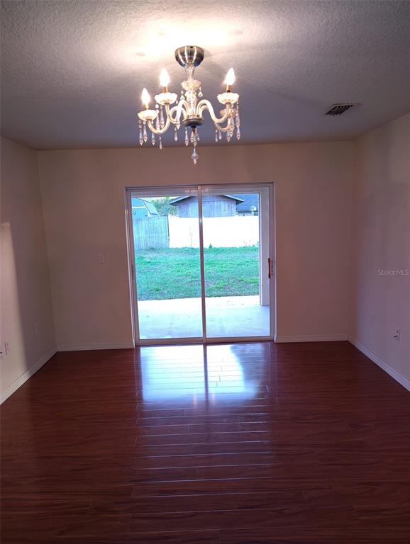 153 Rosedale Avenue Spring Hill, FL 34606 - Photo 8 of 16 a view of a livingroom with a chandelier wooden floor and a chandelier