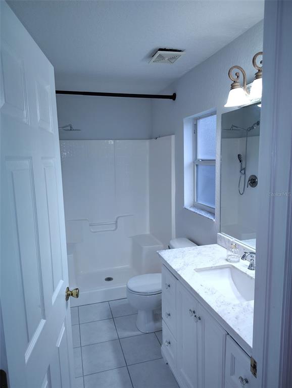 153 Rosedale Avenue Spring Hill, FL 34606 - Photo 9 of 16 a bathroom with a granite countertop sink a toilet and shower