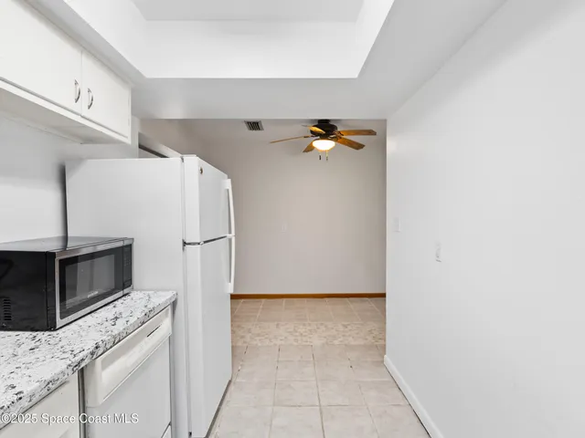 a kitchen with granite countertop a refrigerator and a stove