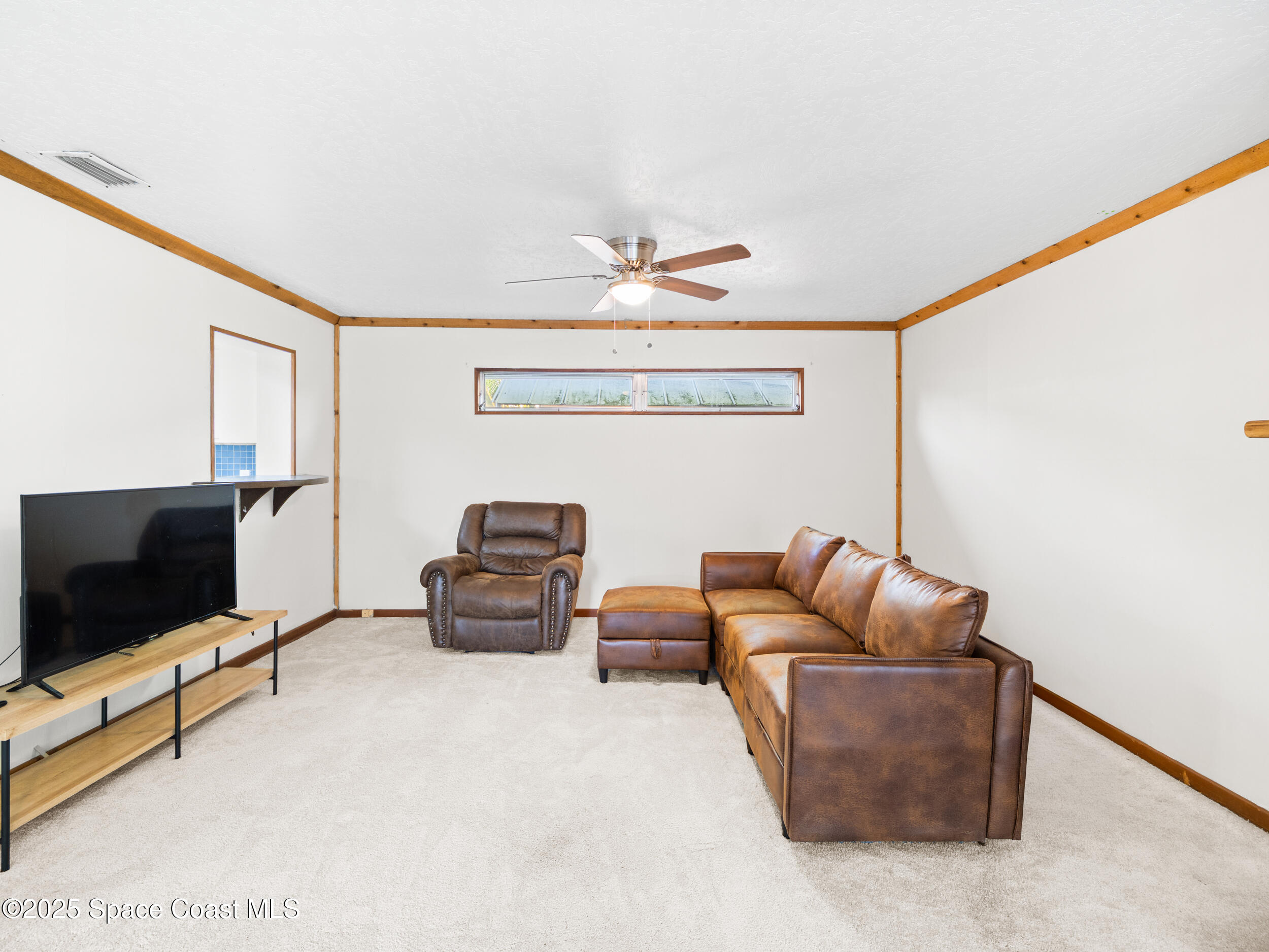 322 3rd Street Merritt Island, FL 32953 - Photo 24 of 38 a living room with furniture and a flat screen tv