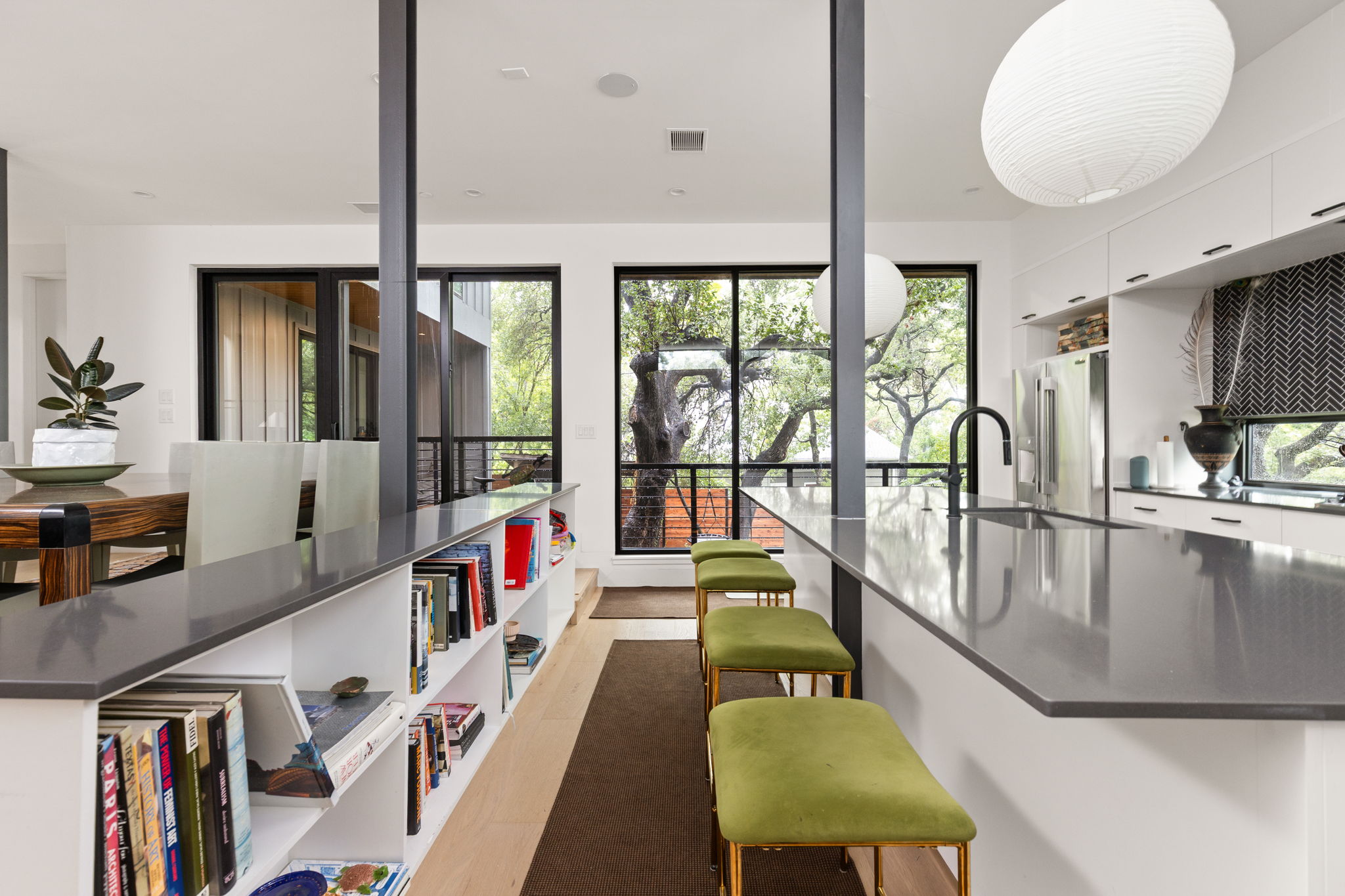 1603 Chelsea Lane, Unit 1 Austin, TX 78704 - Photo 15 of 34 Floor-to-ceiling windows frame verdant tree views from the streamlined kitchen and dining areas.