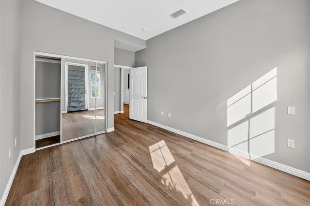an empty room with wooden floor and closet