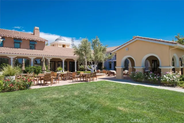 a front view of a house with a yard and a large tree