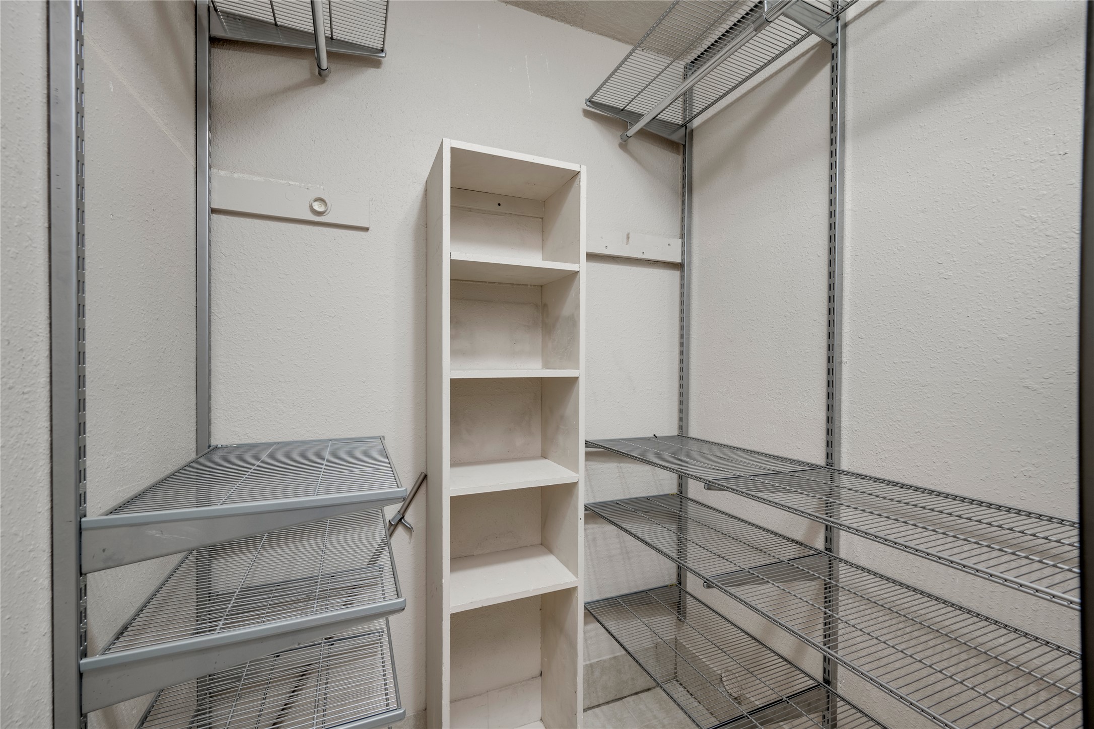 3627 Menchaca Road, Unit 108 Austin, TX 78704 - Photo 17 of 24 Organized storage options fill a spacious walk-in closet featuring extensive built-in shelving systems.