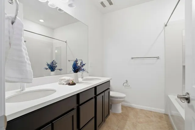 a bathroom with a sink a toilet a light fixture and a mirror