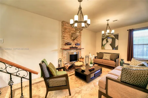 a living room with furniture a fireplace and a chandelier