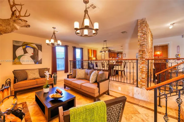 a living room with furniture a rug and a chandelier
