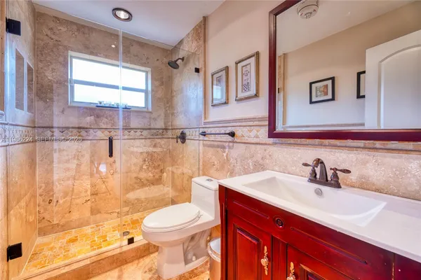 a bathroom with a sink a toilet and shower