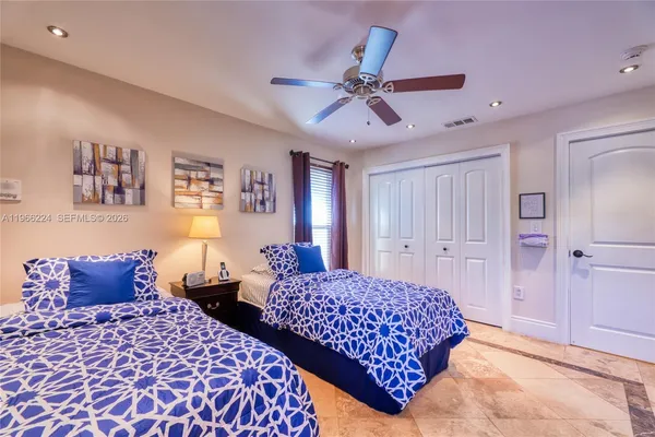 a bedroom with two beds and painting on the wall