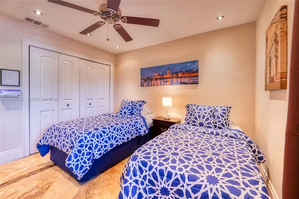 a bedroom with two large bed and a chandelier