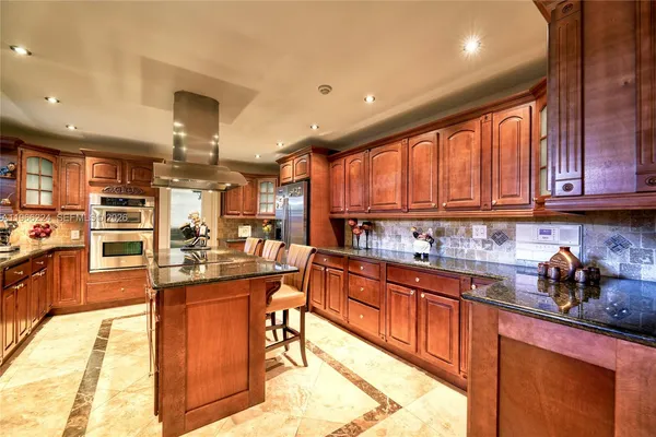 a kitchen with stainless steel appliances granite countertop wooden cabinets a sink and a stove