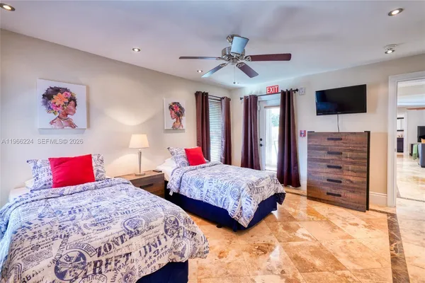 a bedroom with two beds and a flat screen tv