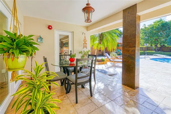 a view of a porch with dining table and chairs