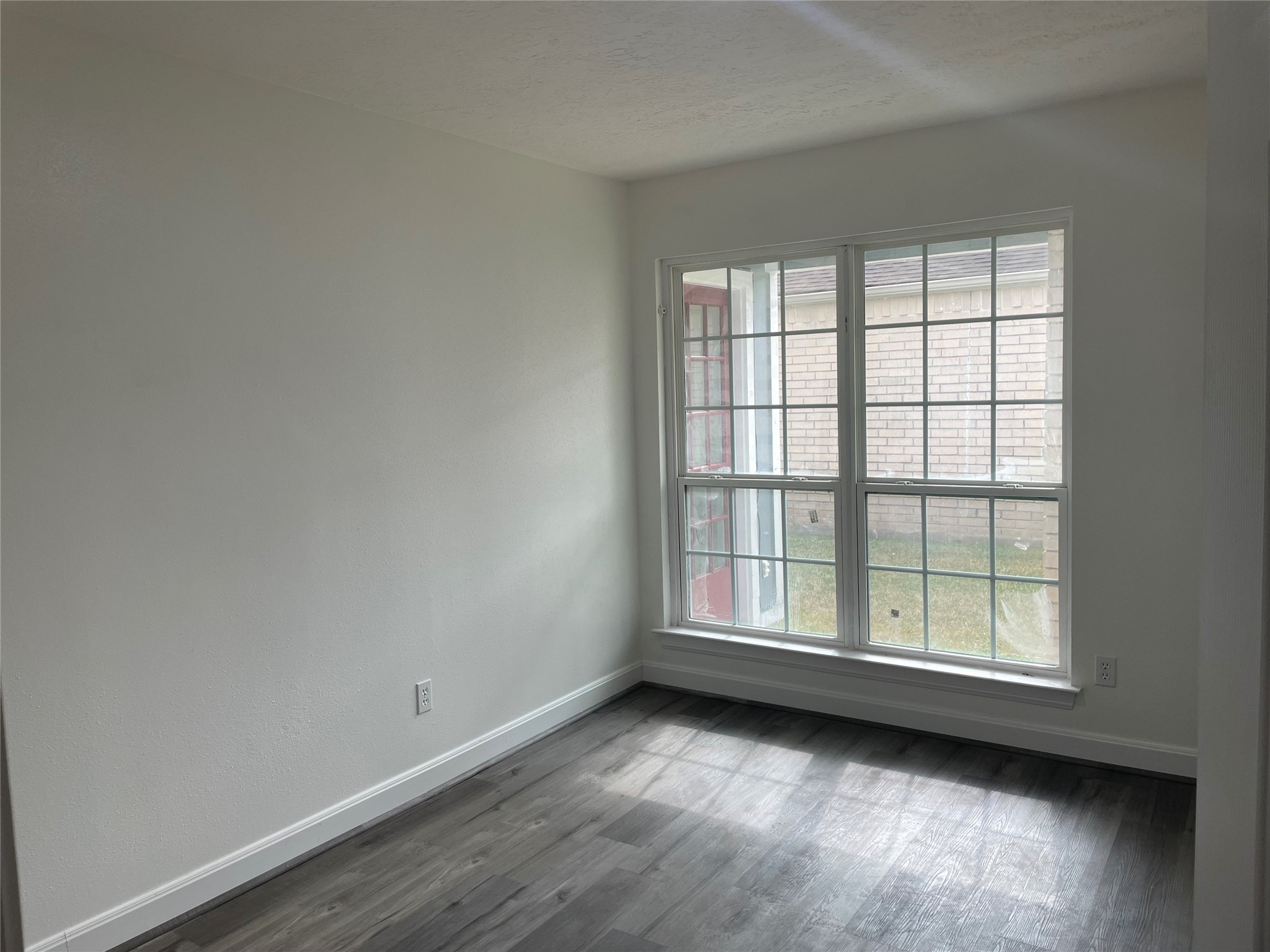 11630 Coachfield Lane Houston, TX 77035 - Photo 13 of 18 an empty room with wooden floor and windows