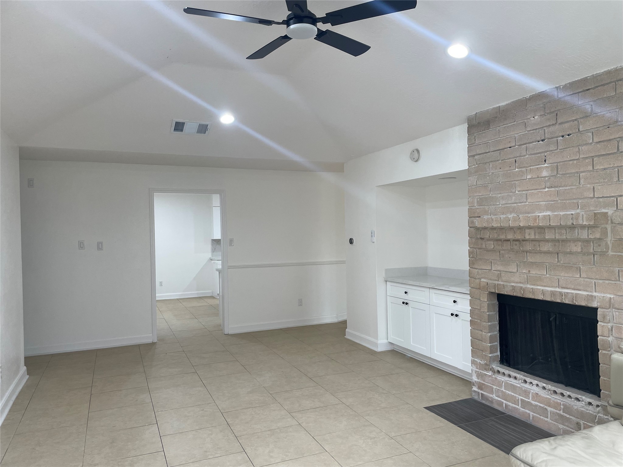 11630 Coachfield Lane Houston, TX 77035 - Photo 8 of 18 an empty room with fireplace and fan