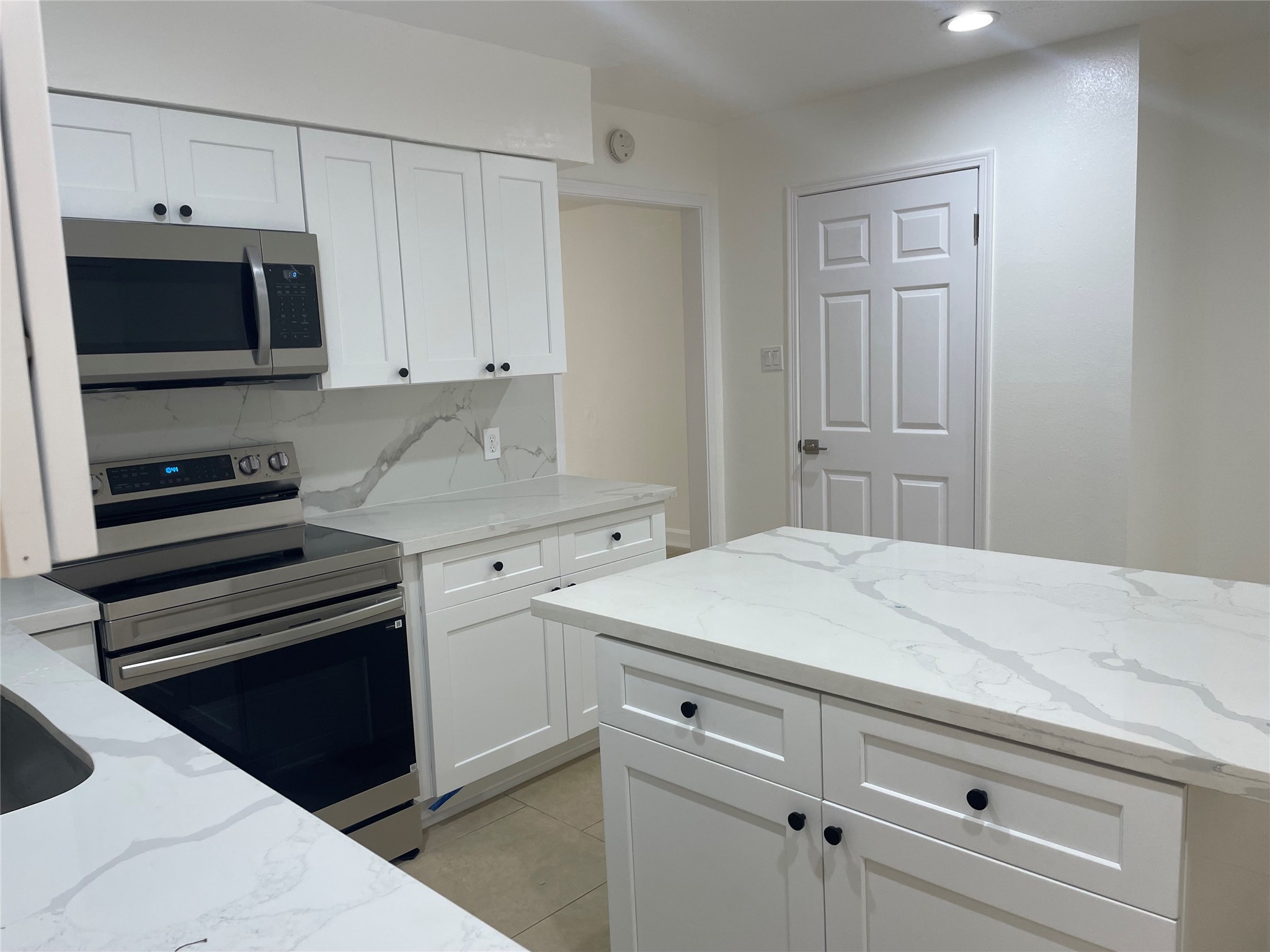 11630 Coachfield Lane Houston, TX 77035 - Photo 10 of 18 a kitchen with white cabinets and stainless steel appliances