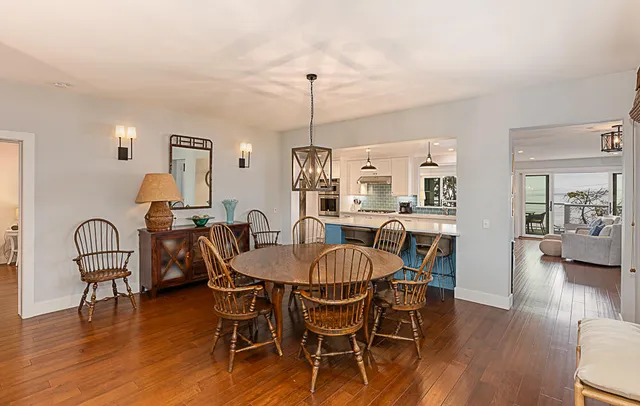 a dining room with furniture a chandelier and wooden floor
