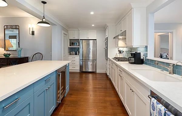 a large kitchen with kitchen island wooden floor a center island stainless steel appliances and a sink