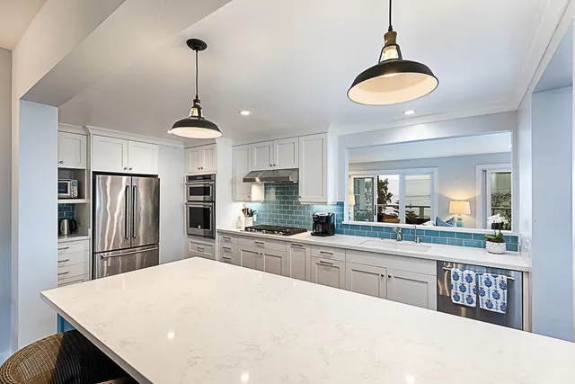 a kitchen with stainless steel appliances a table chairs and refrigerator
