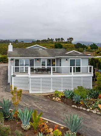 a front view of a house with a garden