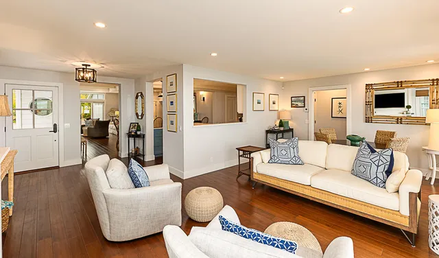 a living room with furniture a flat screen tv and a wooden floor