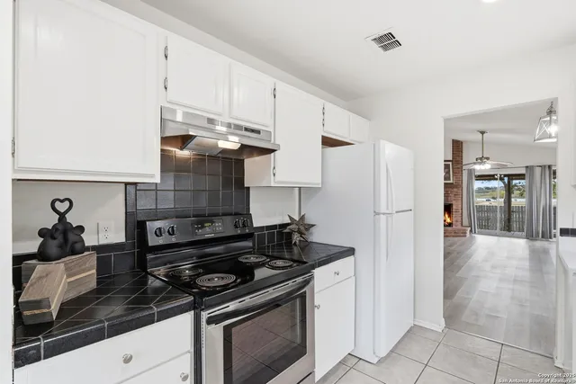 a kitchen with stainless steel appliances granite countertop a stove and a refrigerator