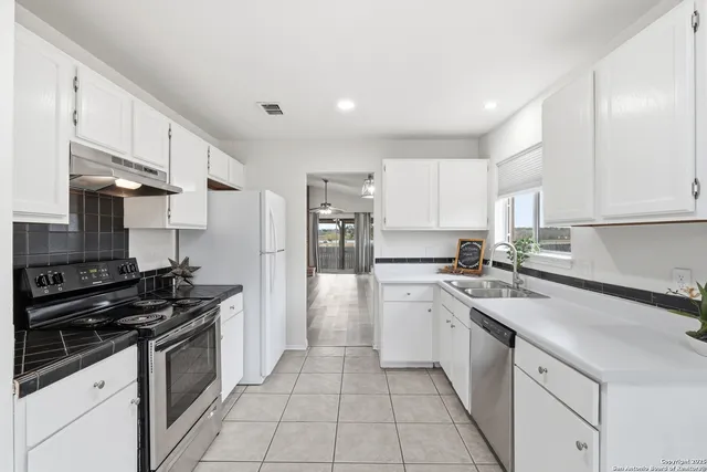 a kitchen with stainless steel appliances a sink stove top oven and cabinets