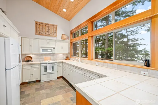 a large white kitchen with sink and cabinets