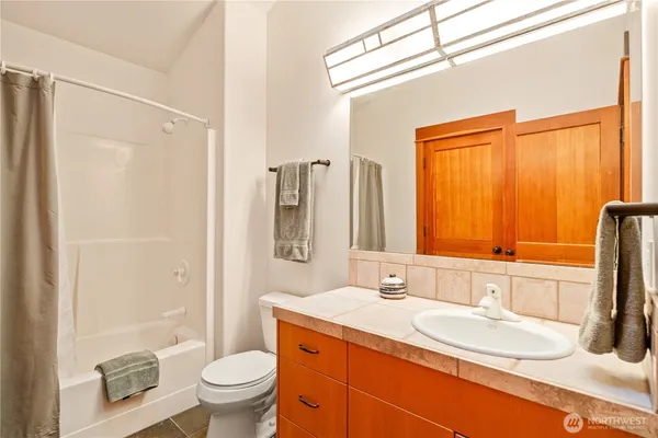 a bathroom with a granite countertop sink toilet and shower