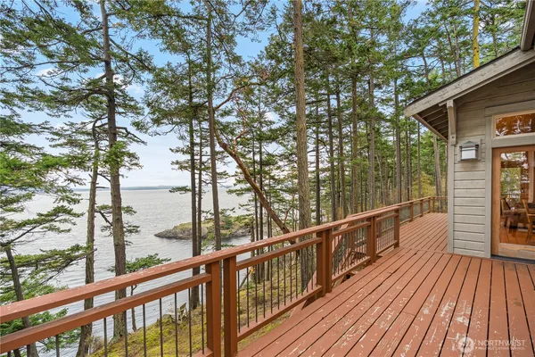 a view of a balcony with wooden floor next to a iron stairs