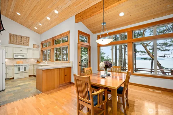 a dining hall with stainless steel appliances granite countertop a dining table and chairs with wooden floor
