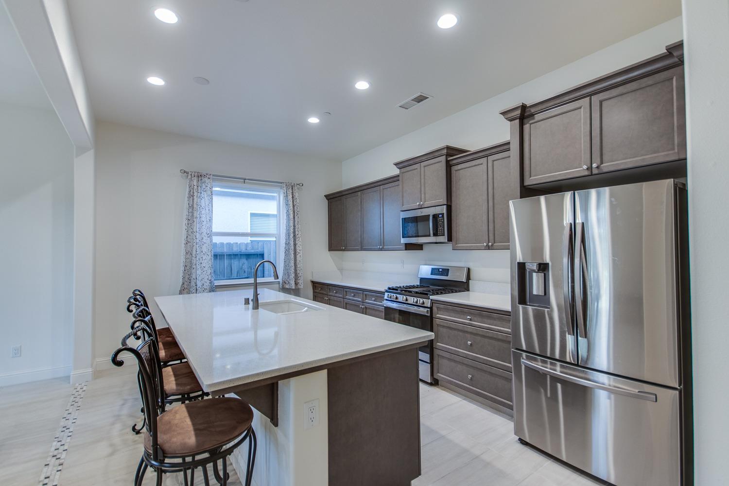 3027 Twain Avenue Clovis, CA 93619 - Photo 11 of 32 a kitchen with stainless steel appliances a refrigerator stove microwave and cabinets