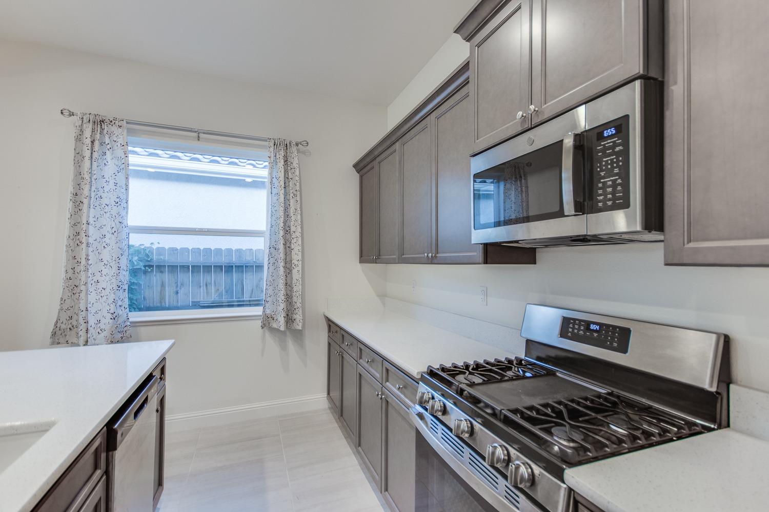 3027 Twain Avenue Clovis, CA 93619 - Photo 12 of 32 a kitchen with a stove and a microwave