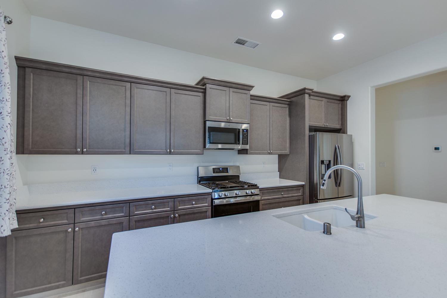 3027 Twain Avenue Clovis, CA 93619 - Photo 13 of 32 a kitchen with granite countertop a stove and a refrigerator