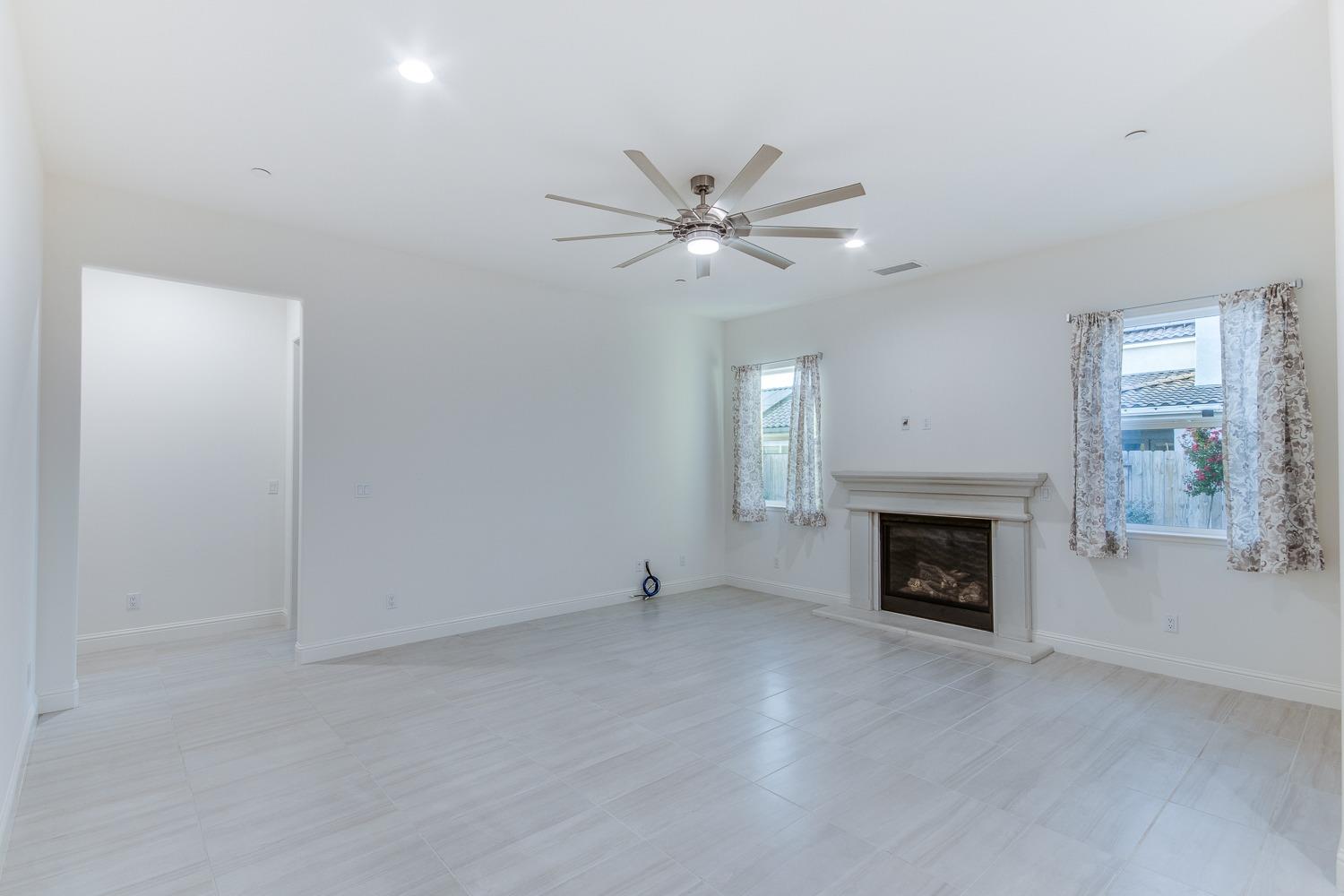 3027 Twain Avenue Clovis, CA 93619 - Photo 16 of 32 an empty room with a fireplace and fan
