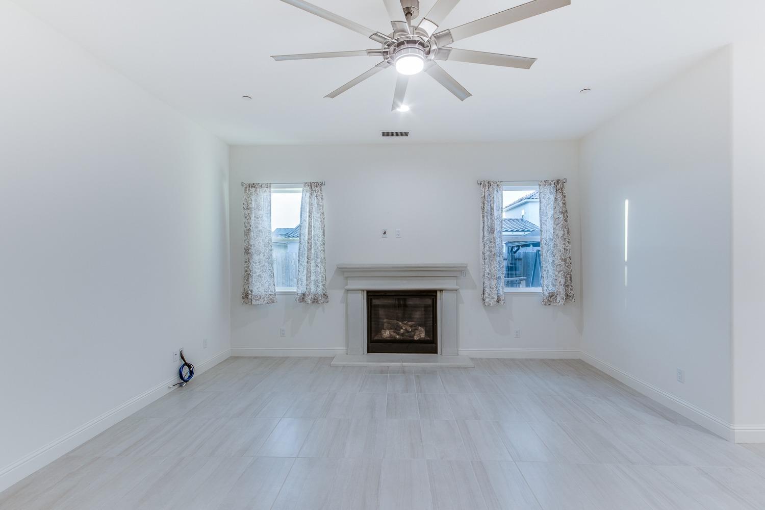 3027 Twain Avenue Clovis, CA 93619 - Photo 17 of 32 wooden floor fireplace and windows in an empty room