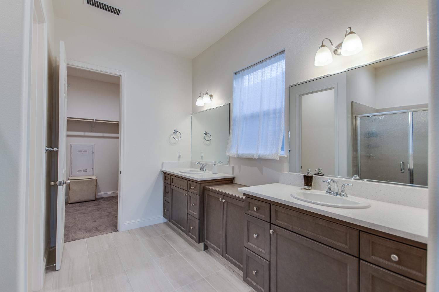 3027 Twain Avenue Clovis, CA 93619 - Photo 21 of 32 a bathroom with a sink double vanity and a mirror