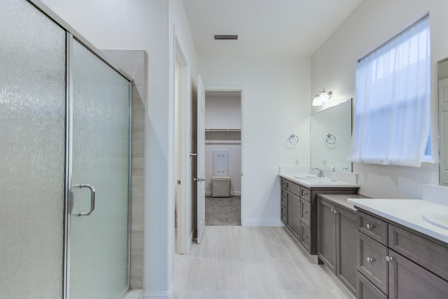 3027 Twain Avenue Clovis, CA 93619 - Photo 22 of 32 a view of a bathroom with a sink and mirror