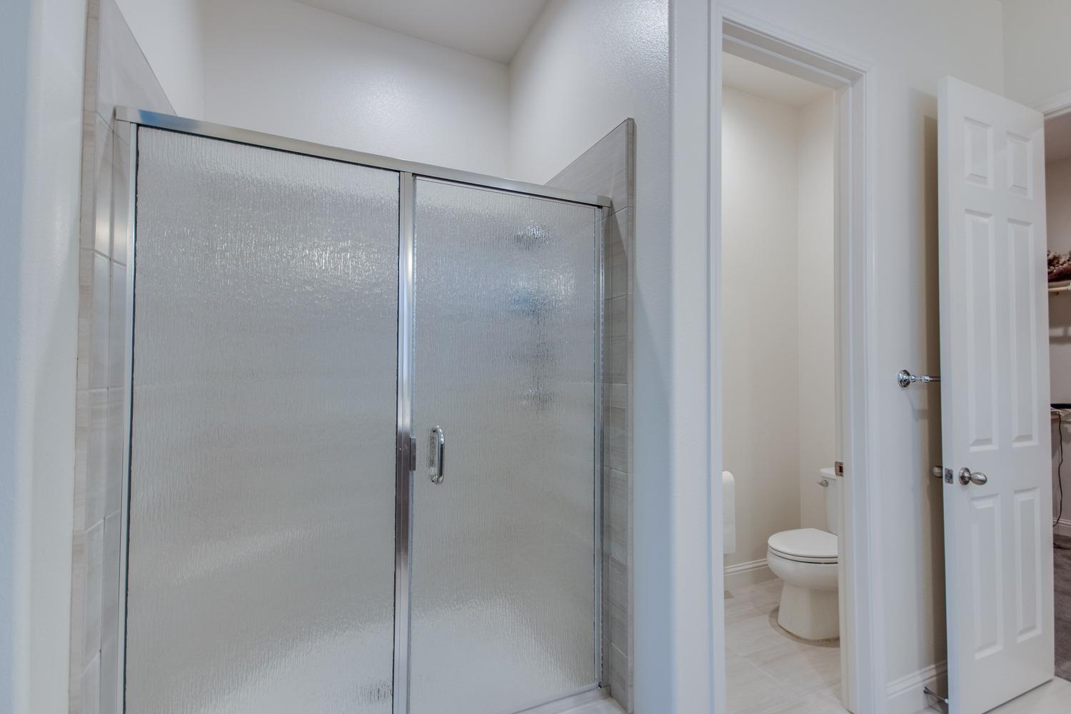 3027 Twain Avenue Clovis, CA 93619 - Photo 23 of 32 a bathroom that has a glass shower door