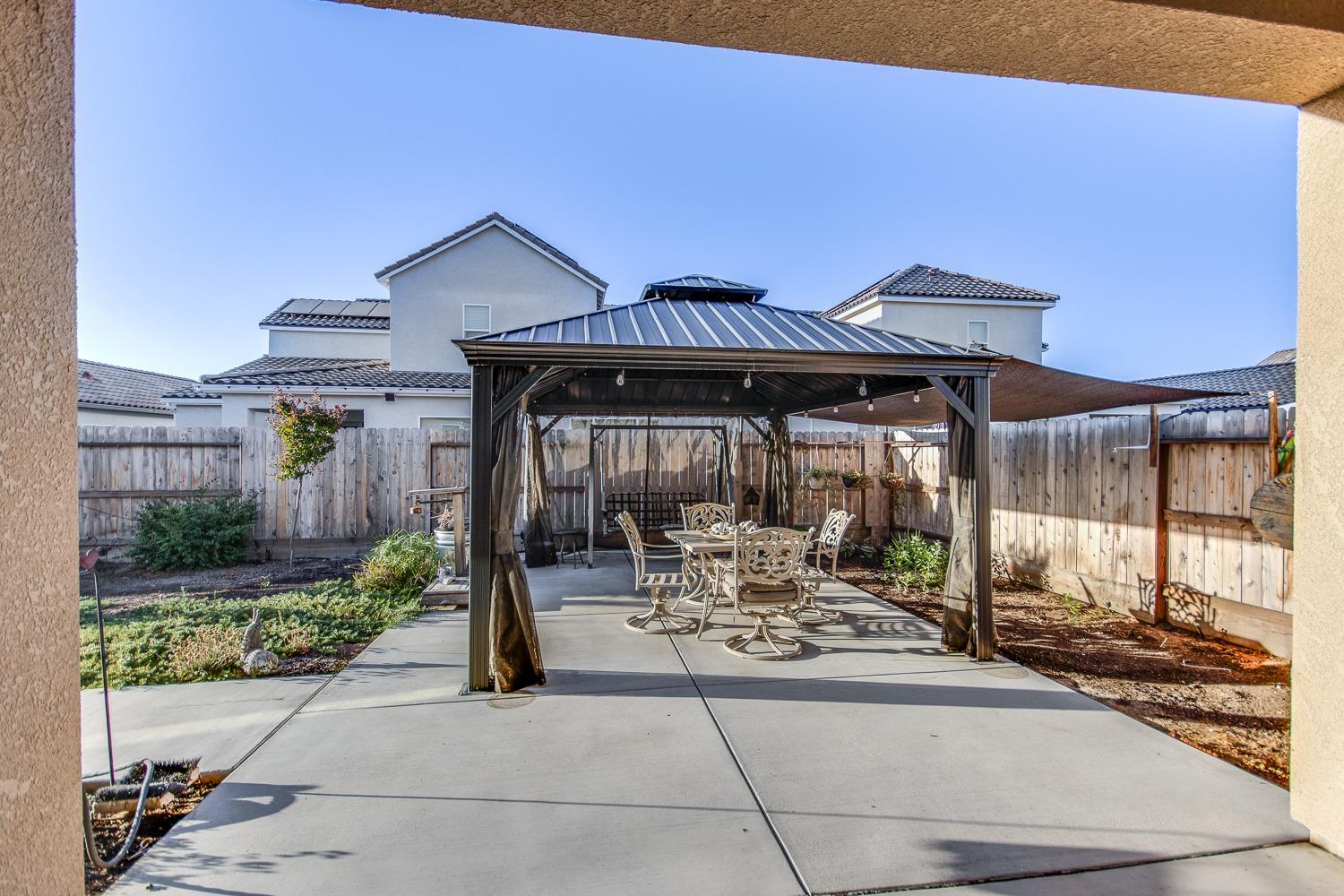 3027 Twain Avenue Clovis, CA 93619 - Photo 28 of 32 a patio with a table and chairs under an umbrella